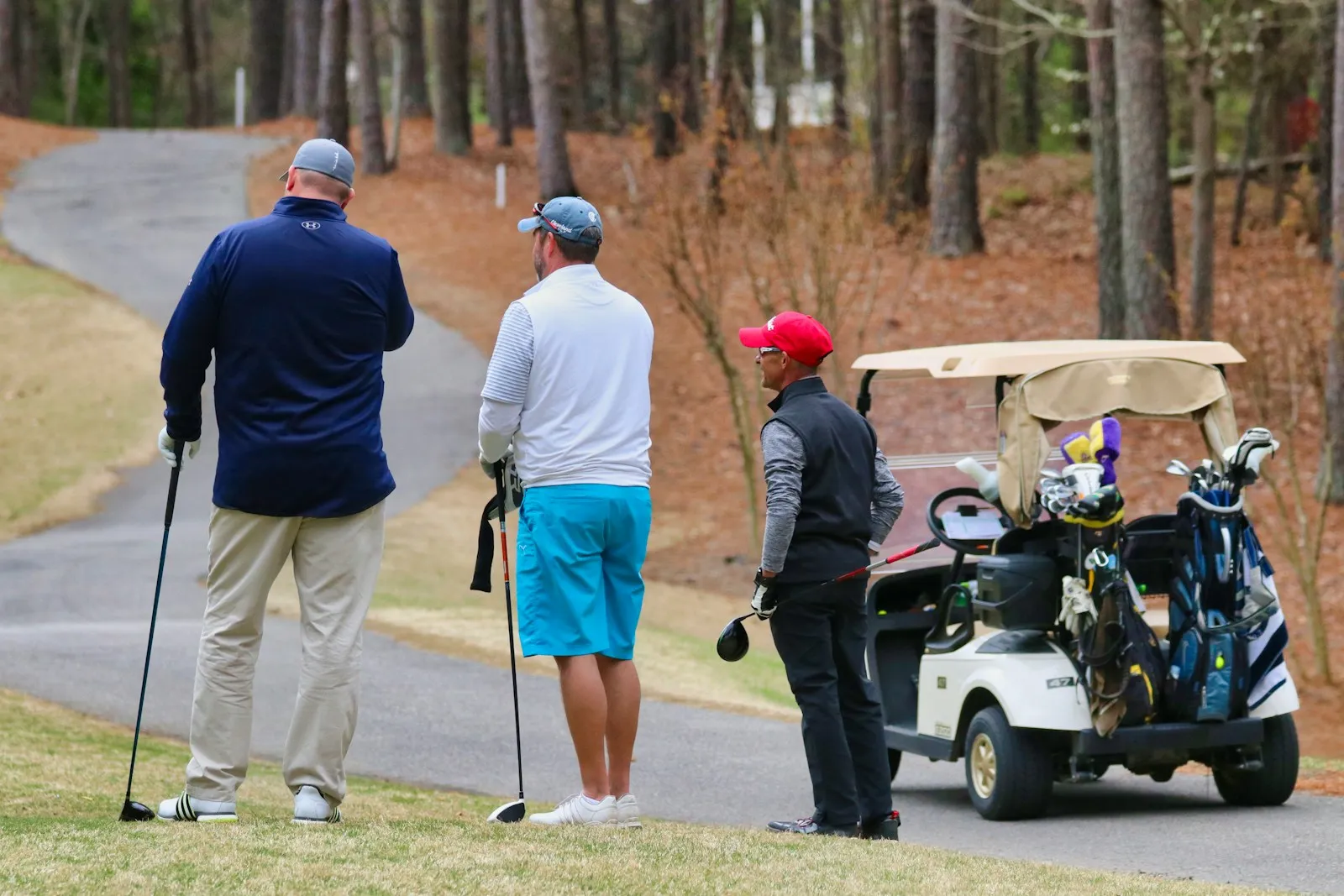 Deux golfeurs qui jasent dans une voiturette entre deux trous.